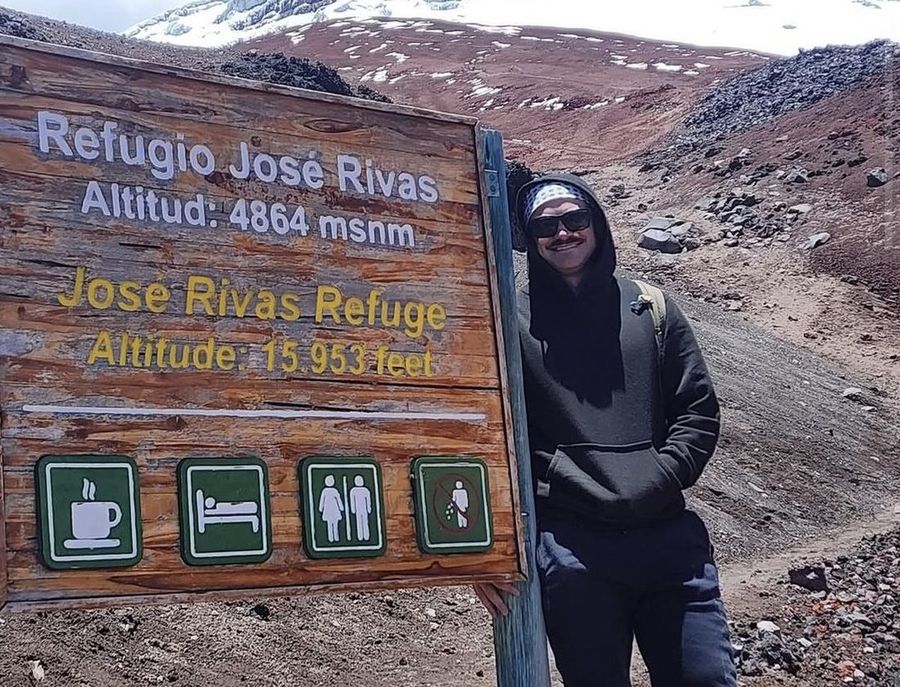 Ian Treger junto al cartel del Refugio José Rivas, en un volcán con nieve.