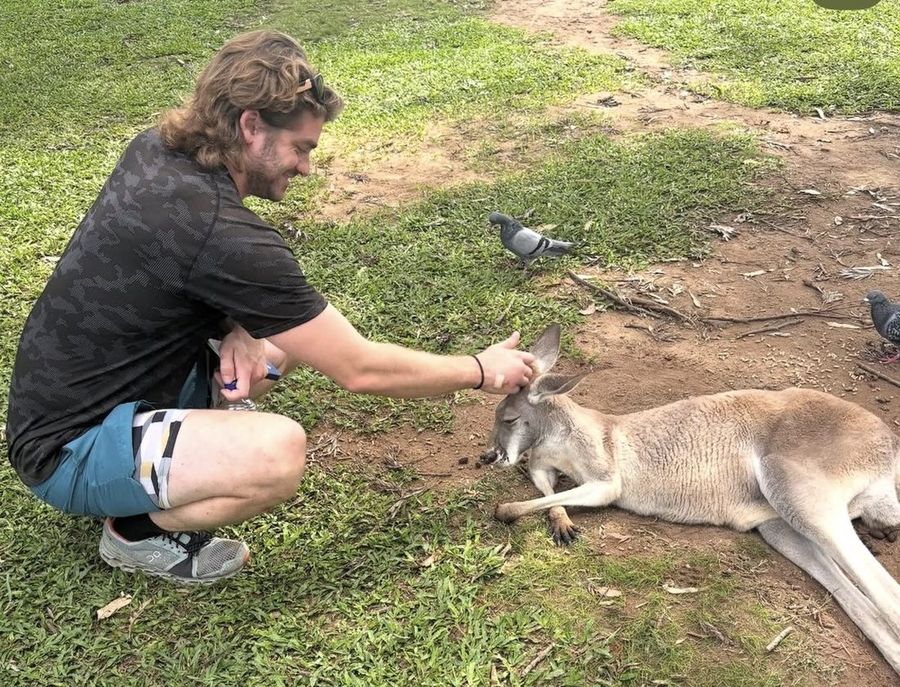 Ian consolando a un canguro en un centro de rescate en Australia.
